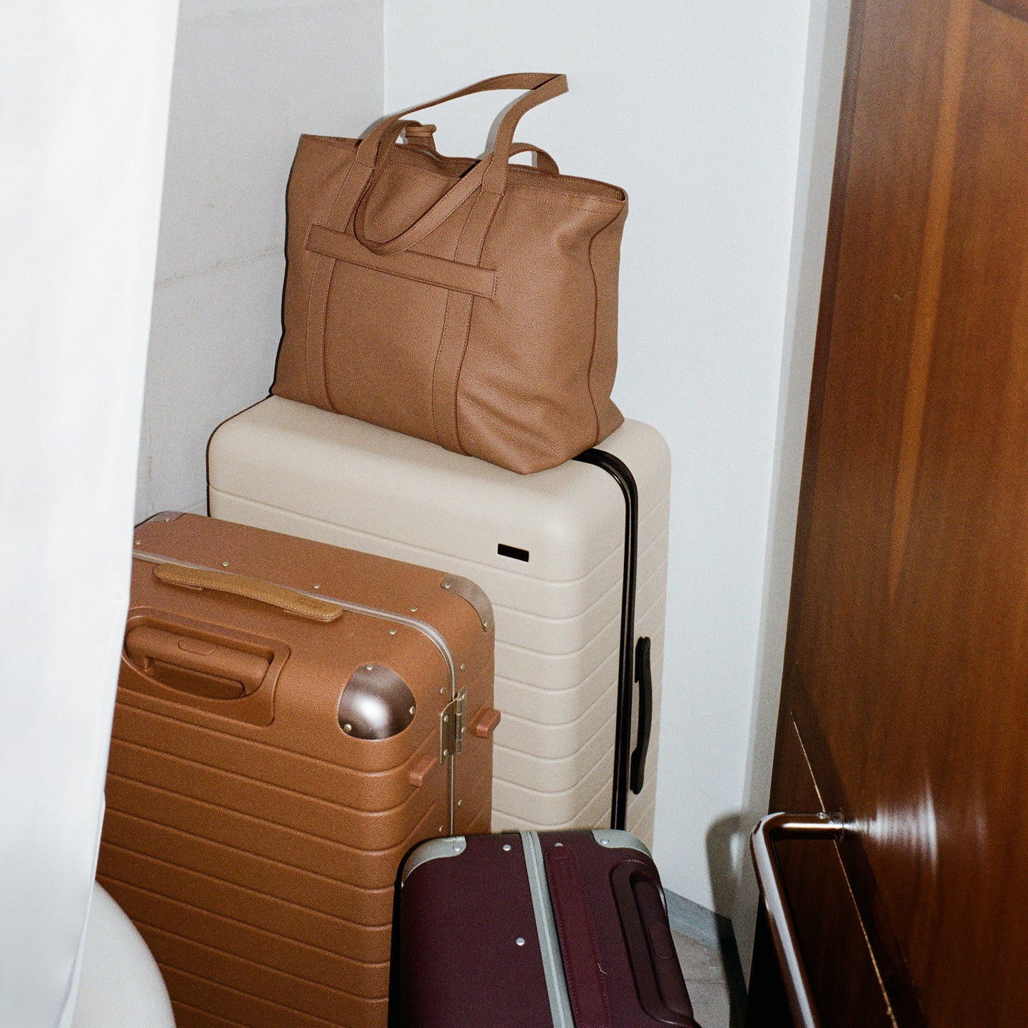 Leather travel tote stacked on top of The Medium in Salt White.