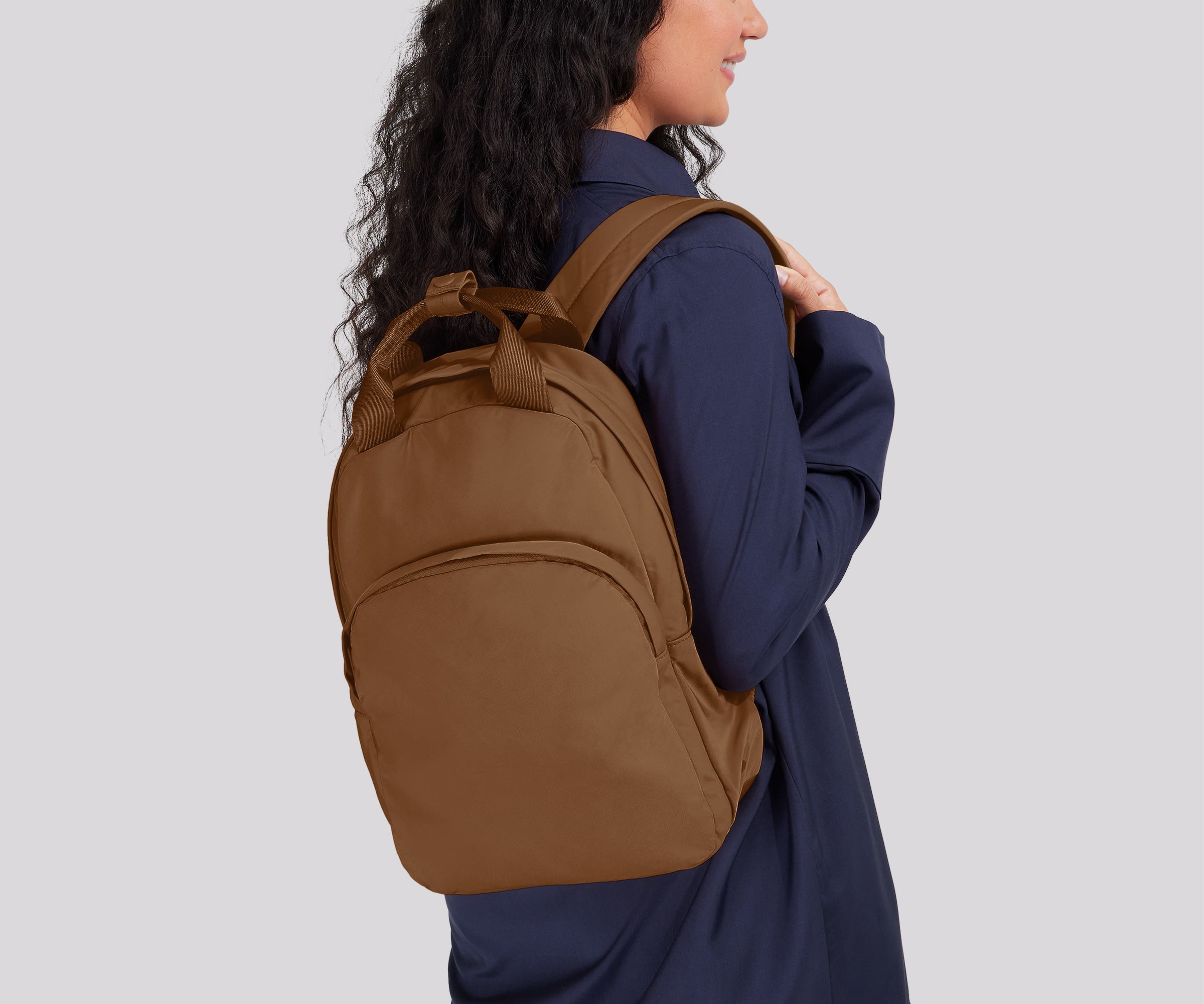 Person wearing the Featherlight Backpack on one shoulder
// 
Model is 5'7"