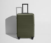 Front product view of The Medium Flex suitcase in Olive Green with raised handle