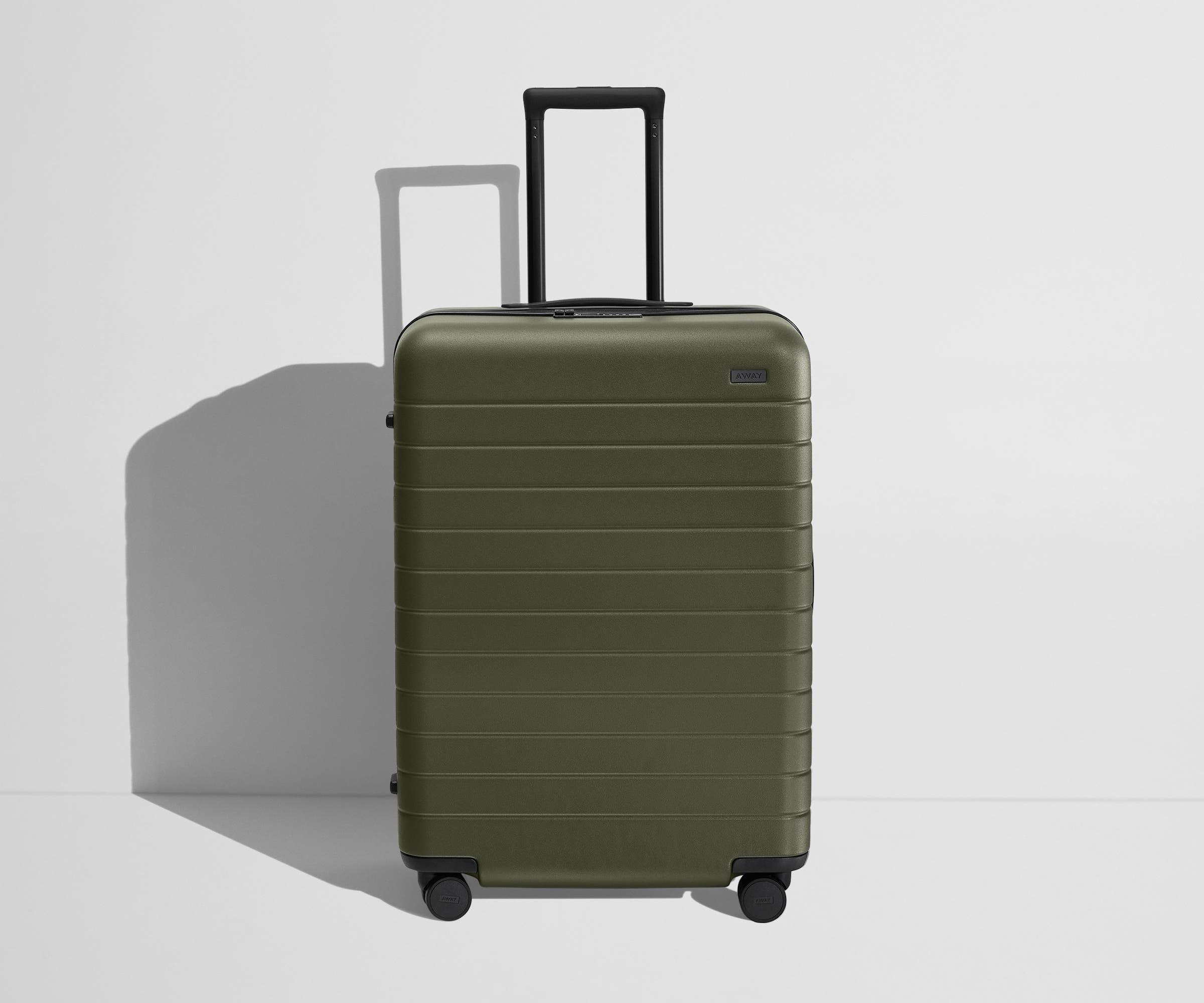 Front product view of The Medium Flex suitcase in Olive Green with raised handle
