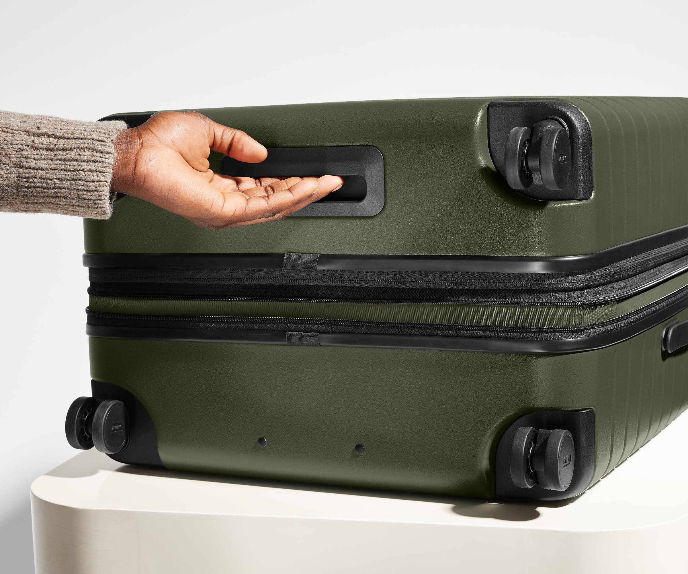 The Medium Flex suitcase in Sea Green shown from below highlighting the underside grab handle