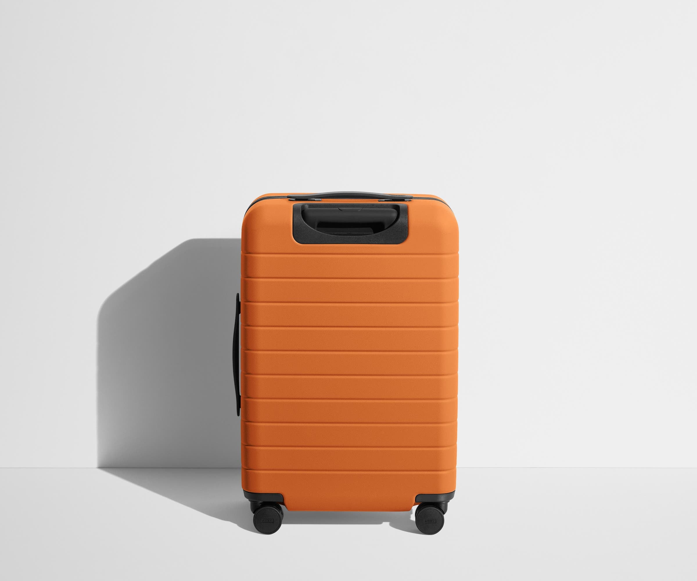 Back product view of The Bigger Carry-On suitcase in Sorbet Orange