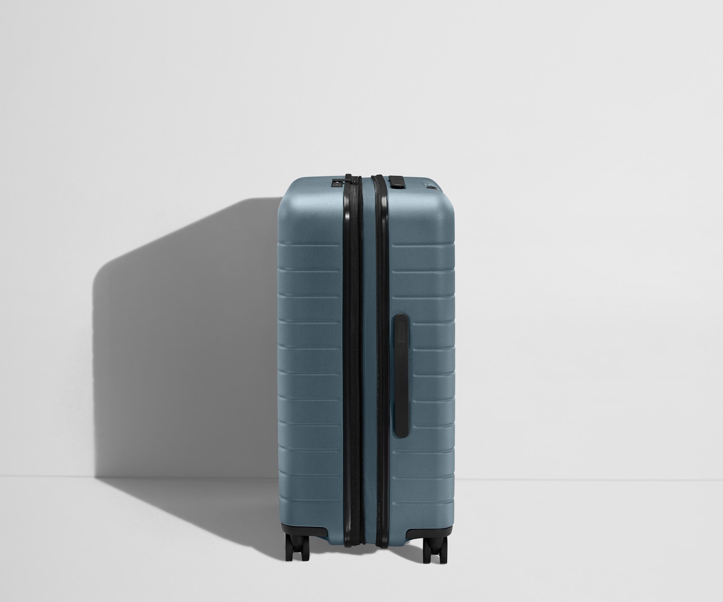 Side product view of The Medium Flex suitcase in Coast Blue shown fully expanded