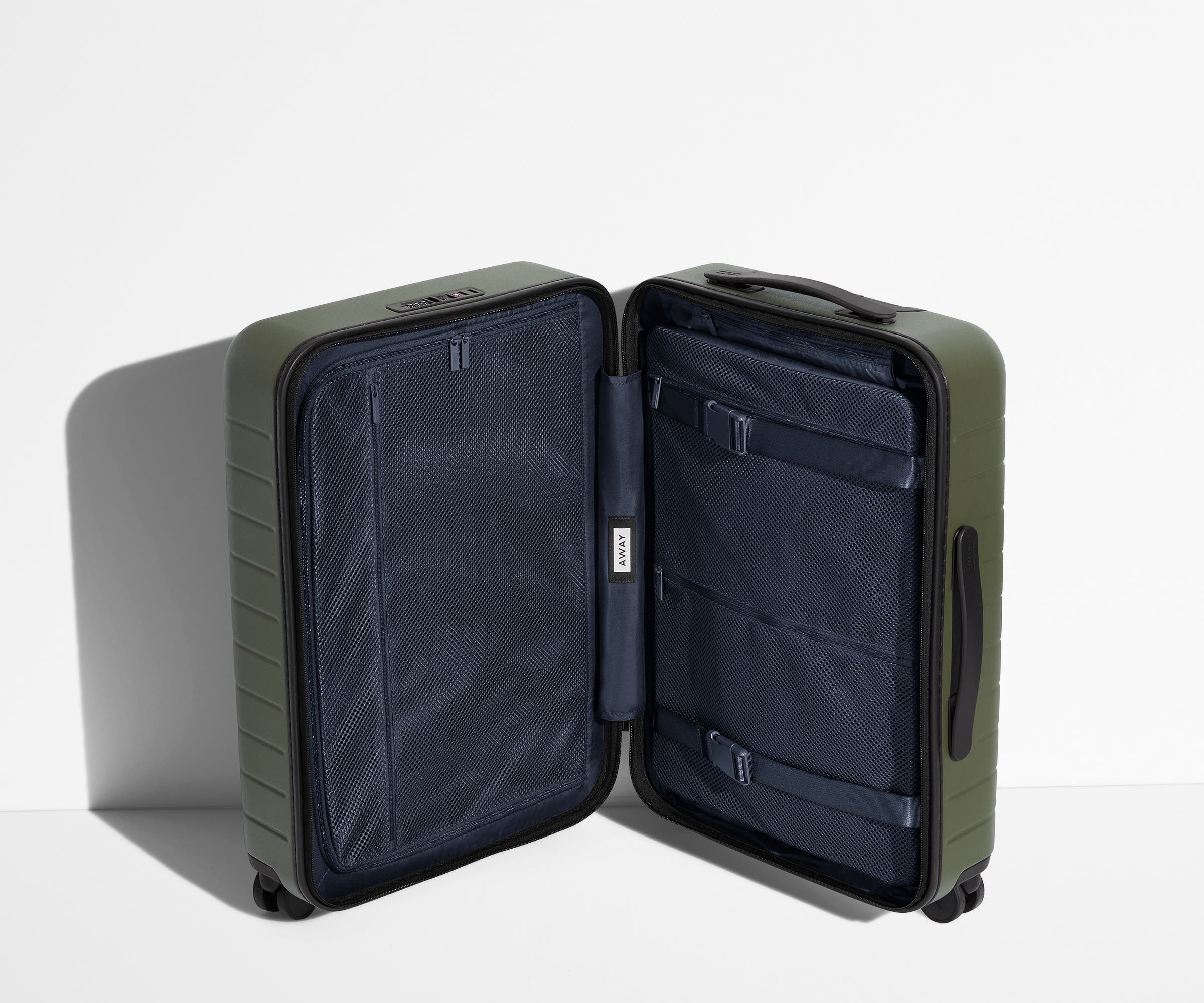 The Bigger Carry-On suitcase in Olive Green shown open in an upright position to show interior organization and compression system