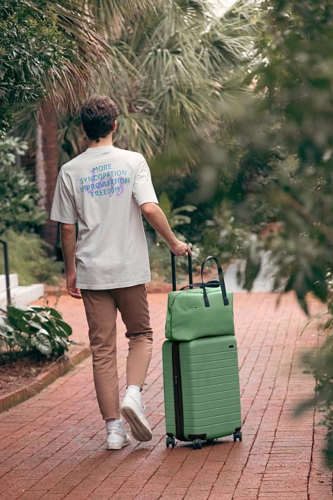 Away's matching Bigger Carry-On and duffle bag in ea Green
