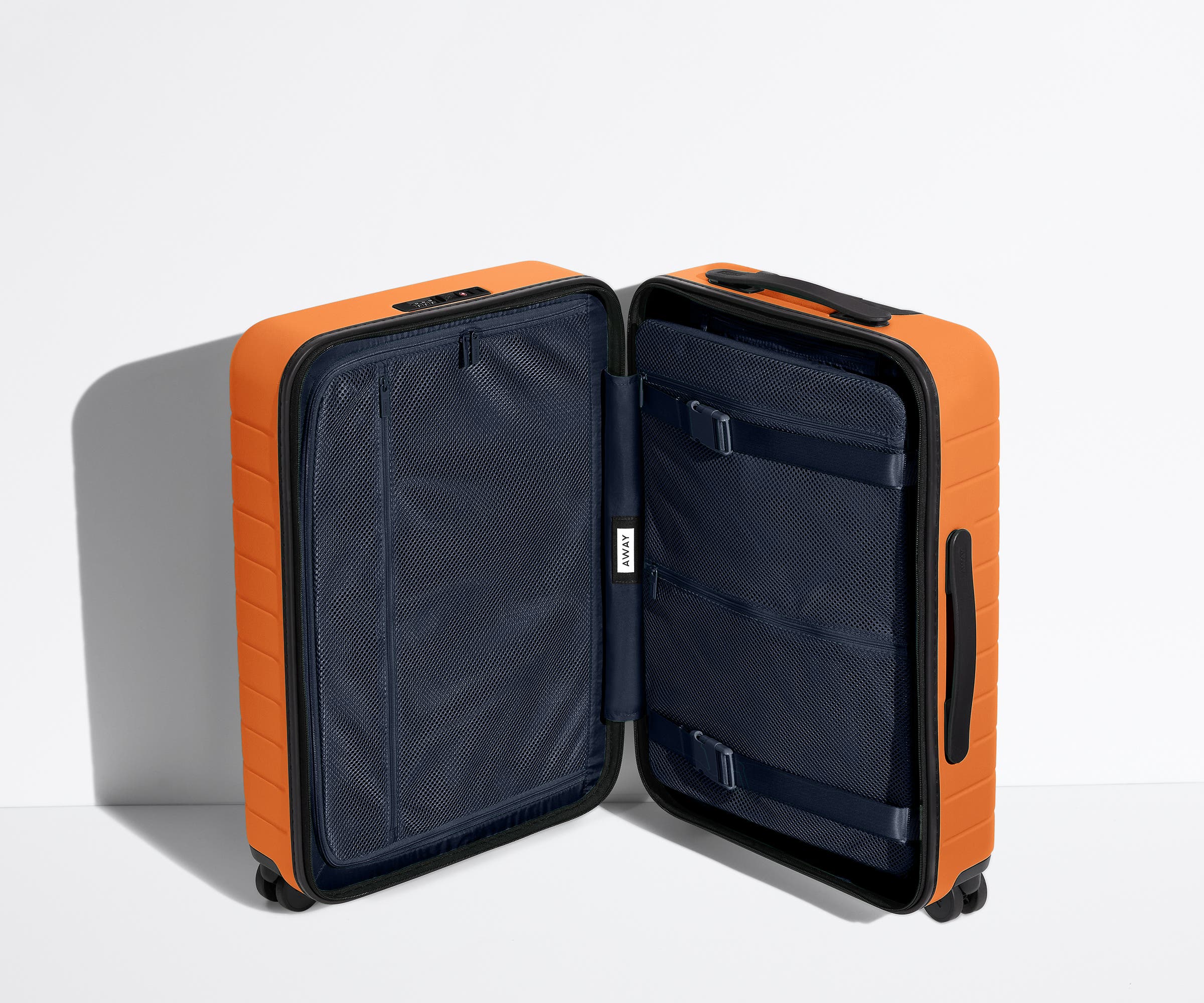 The Bigger Carry-On suitcase in Sorbet Orange shown open in an upright position to show interior organization and compression system