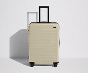 Front product view of The Medium Flex suitcase in Salt White (Gloss) with raised handle