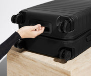 The Bigger Carry-On suitcase in Jet Black shown from below highlighting the underside grab handle