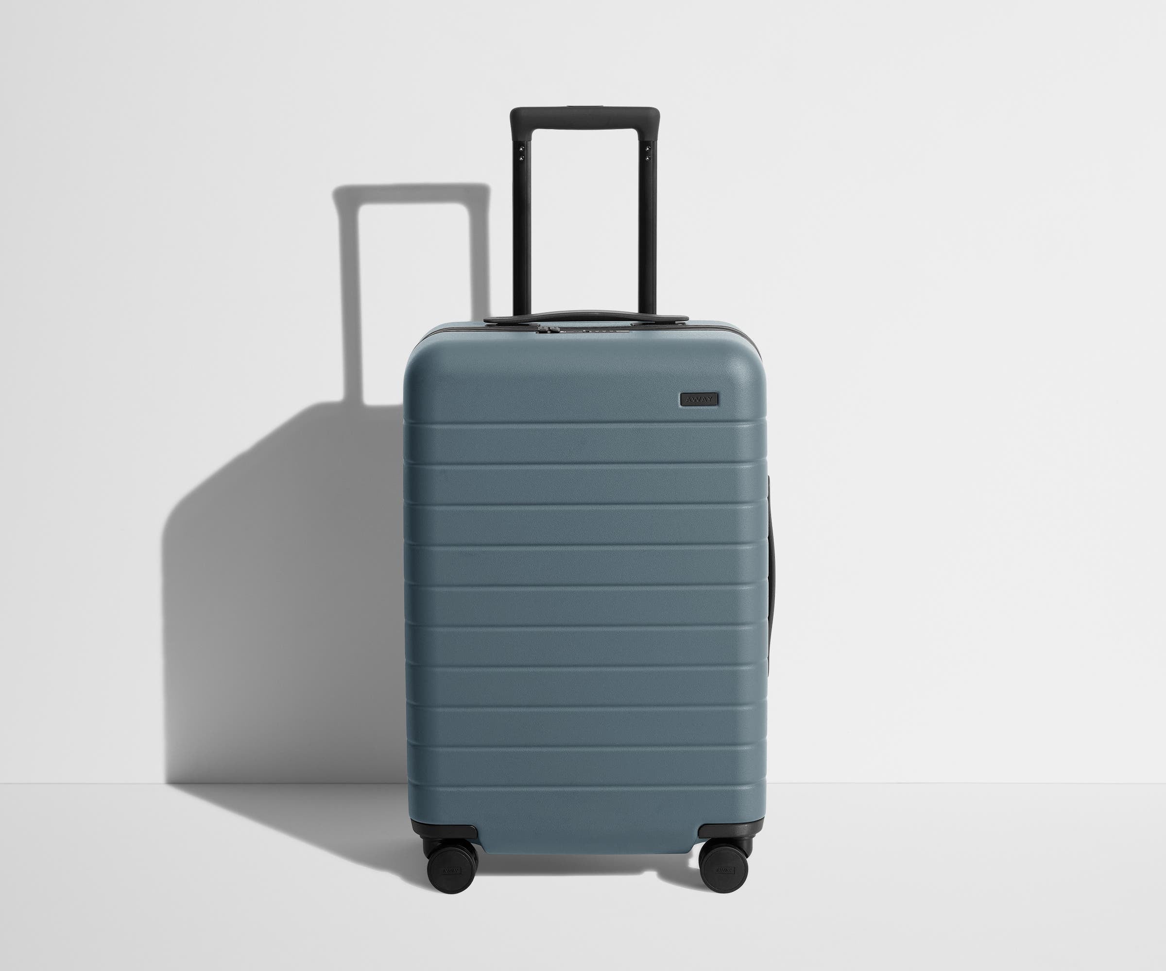 Front product view of The Bigger Carry-On suitcase in Coast Blue with raised handle