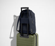 Navy Everywhere Zip Backpack on top of the Away suitcase