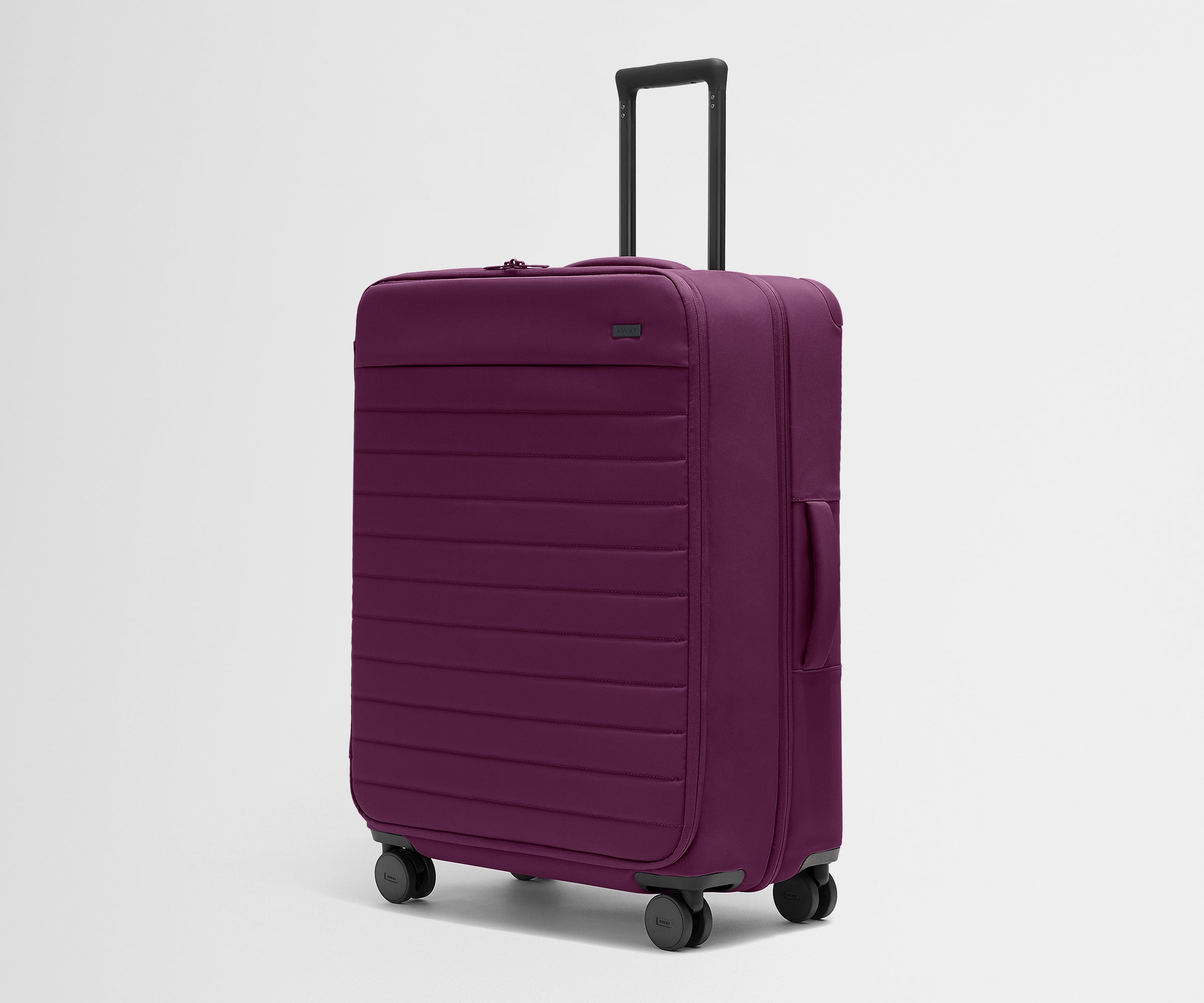 Angled product view of The Softside Large suitcase in Plum Purple with raised handle